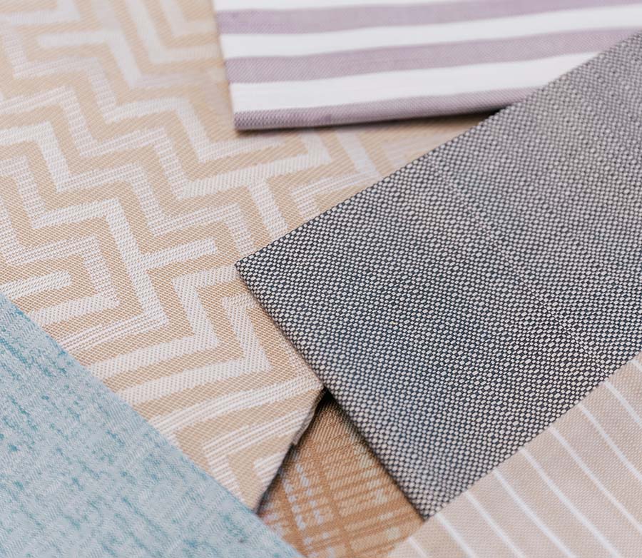 Dettaglio di diversi ritagli di stoffe differenti posti uno sopra l'altro.