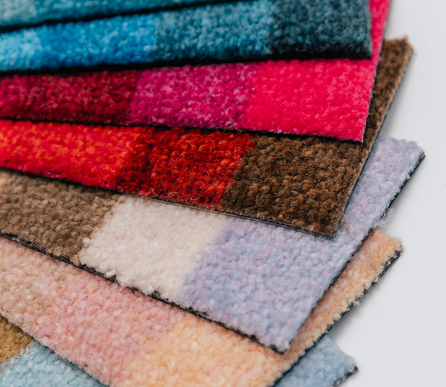 Dettaglio di alcune stoffe da tappeto di diversi colori disposte a ventaglio.