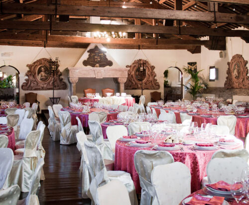 Sala di un ristorante addobbata a festa con tavoli apparecchiati.