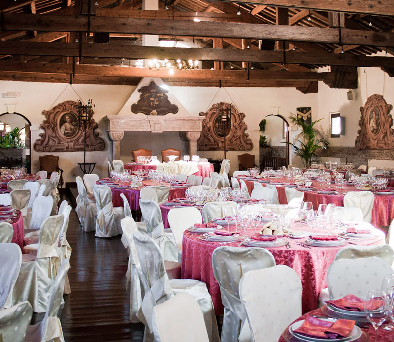 Sala di un ristorante addobbata a festa con tavoli apparecchiati.