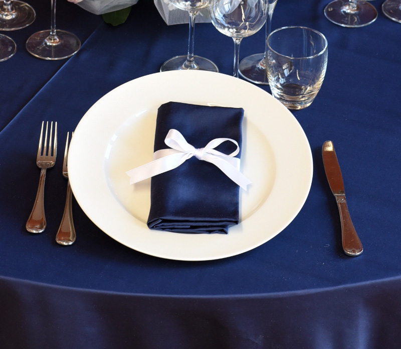 Dettaglio di una tavola apparecchiata con biancheria blu.