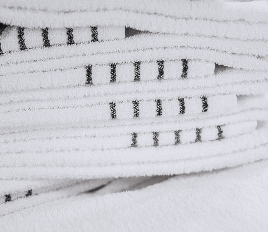 Asciugamani bianchi con delle righe grigie impilati.