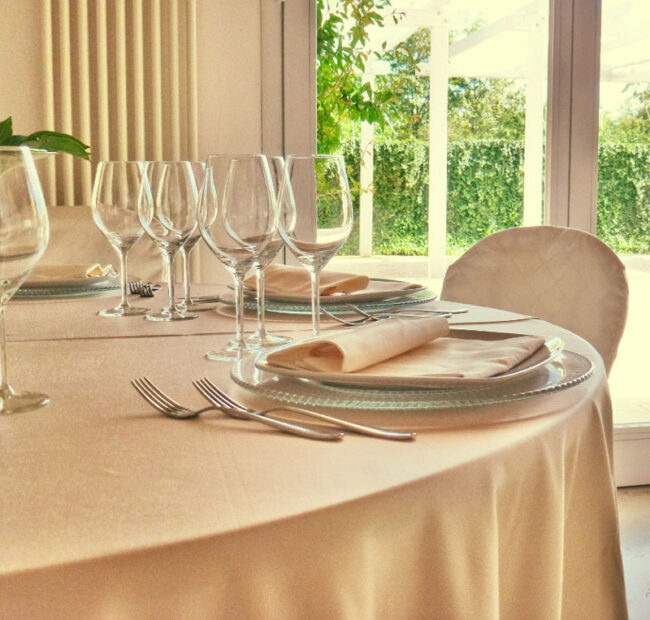 Dettaglio di una tavola apparecchiata con biancheria color avorio.