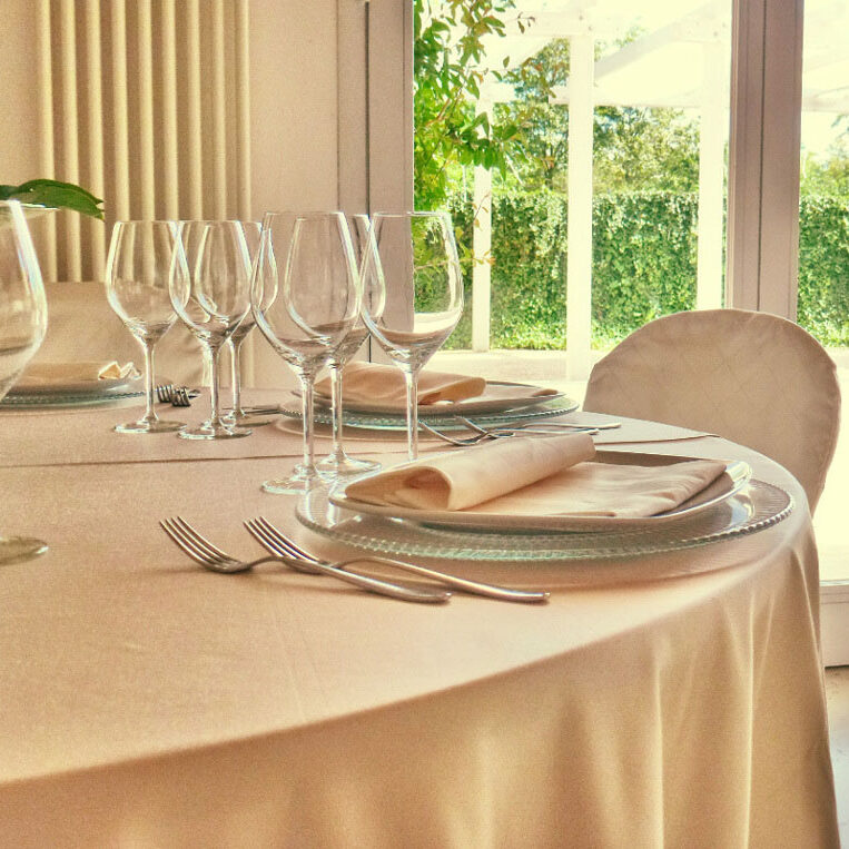 Dettaglio di una tavola apparecchiata con biancheria color avorio.