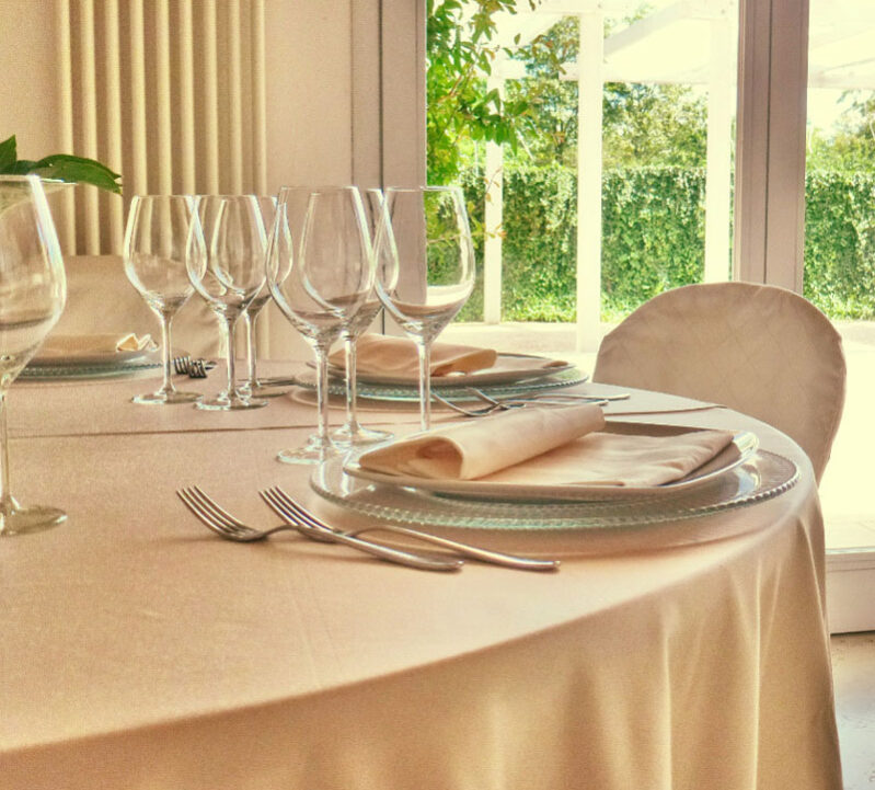 Dettaglio di una tavola apparecchiata con biancheria color avorio.