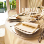 Dettaglio di una tavola apparecchiata con biancheria color avorio.