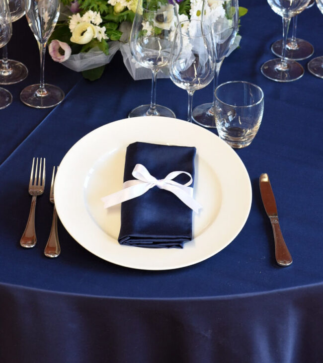 Dettaglio di una tavola apparecchiata con biancheria blu.