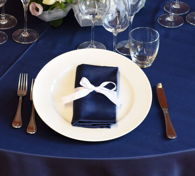 Dettaglio di una tavola apparecchiata con biancheria blu.