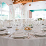 Dettaglio di una tavola apparecchiata con biancheria di lino color bianco.