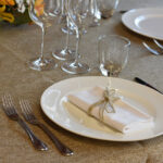 Dettaglio di una tavola apparecchiata con biancheria rustica in juta.