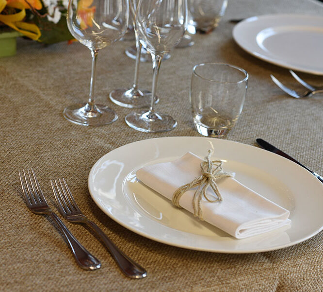 Dettaglio di una tavola apparecchiata con biancheria rustica in juta.