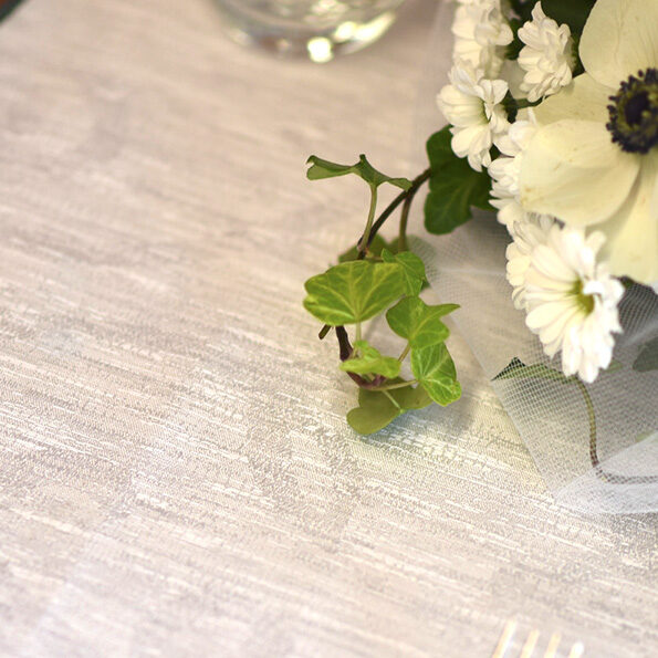 Dettaglio di un mazzo di fiori poggiato su una tovaglia color tortora.