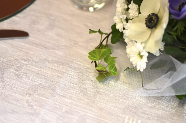 Dettaglio di un mazzo di fiori poggiato su una tovaglia color tortora.