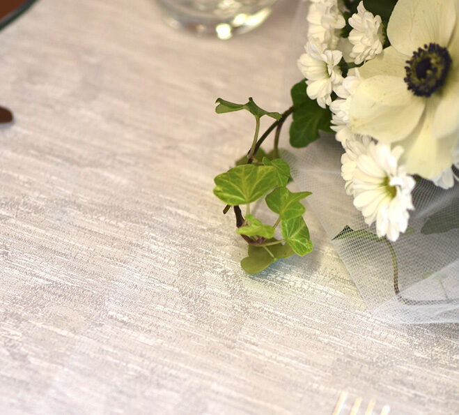 Dettaglio di un mazzo di fiori poggiato su una tovaglia color tortora.